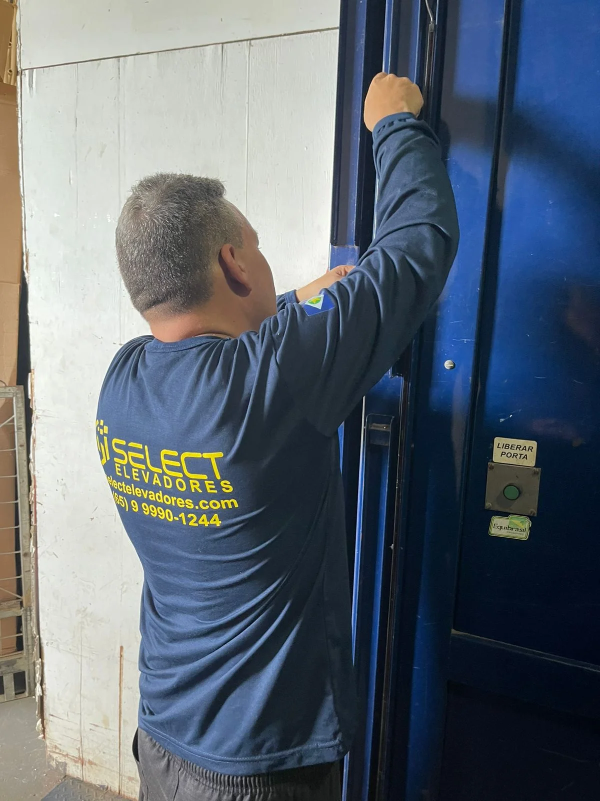 Técnico ajustando painel de porta de elevador