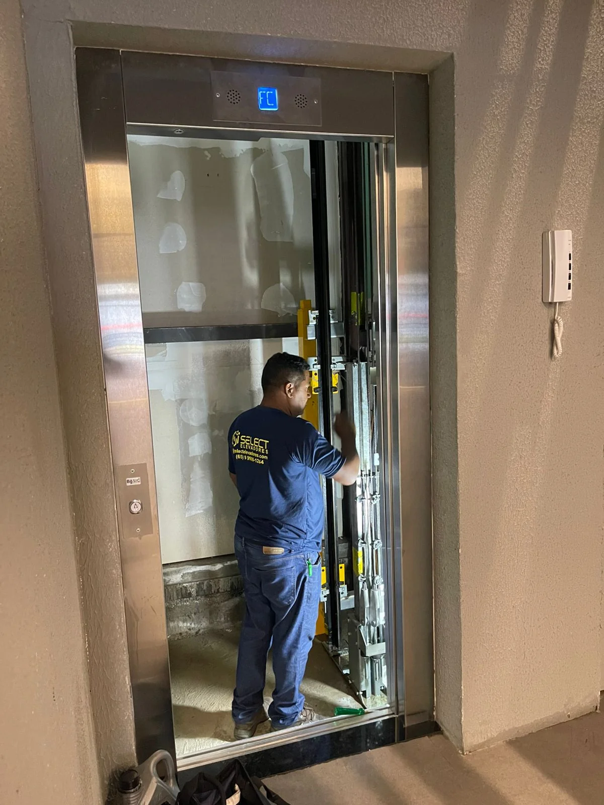 Técnico Select fazendo testes finais no elevador instalado