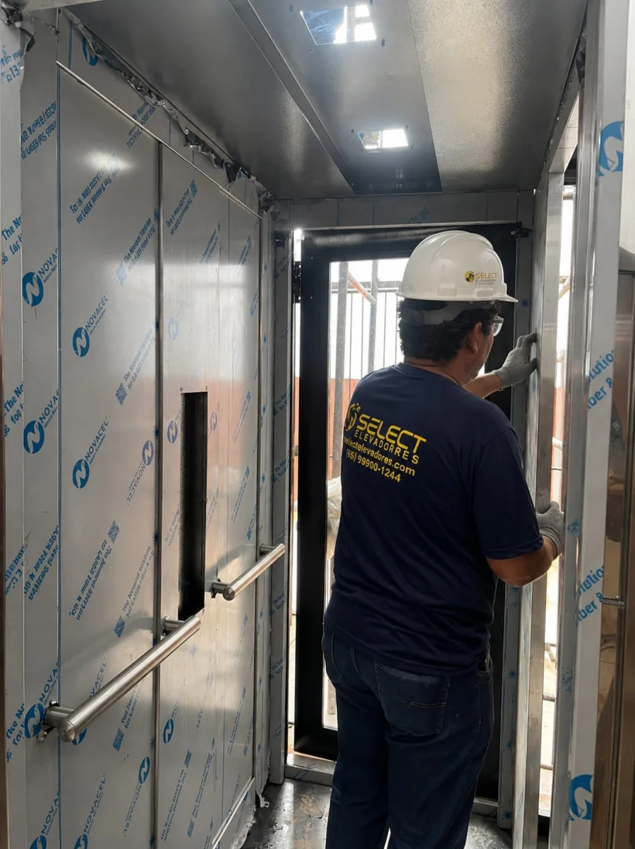 Técnico Select instalando porta de cabine de elevador revestida